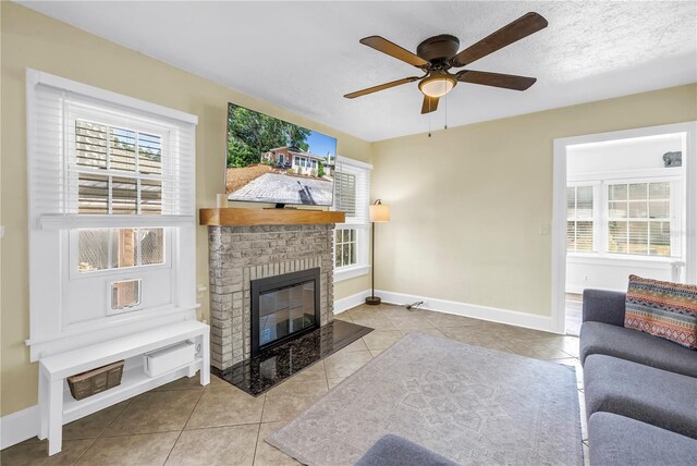 tiled living area with ceiling fan, baseboards, and a fireplace