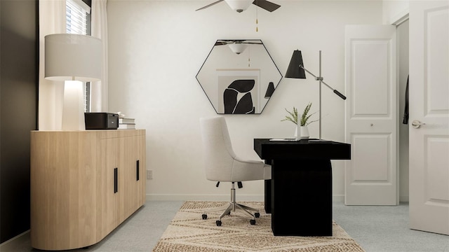 office area featuring light carpet, ceiling fan, and baseboards