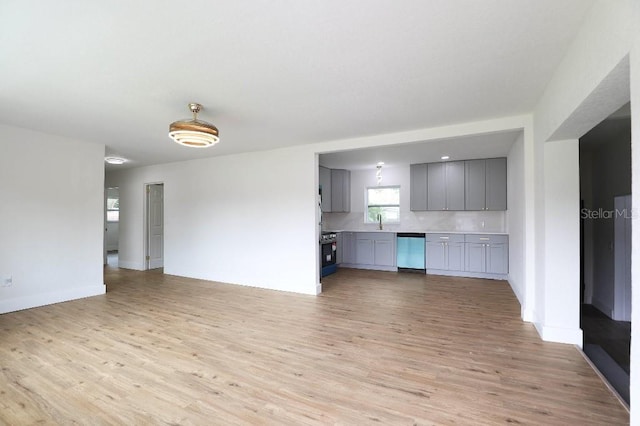 2013 Pineway Dr, Orlando, FL 32839 - unfurnished living room with light wood-style flooring, a sink, and baseboards