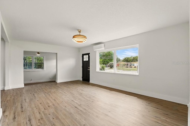 2013 Pineway Dr, Orlando, FL 32839 - empty room with a wall mounted air conditioner, wood finished floors, and baseboards