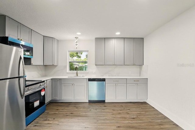 2013 Pineway Dr, Orlando, FL 32839 - kitchen with stainless steel appliances, a sink, gray cabinetry, light countertops, and recessed lighting