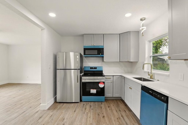 2013 Pineway Dr, Orlando, FL 32839 - kitchen featuring stainless steel appliances, a sink, light wood-type flooring, light countertops, and gray cabinets