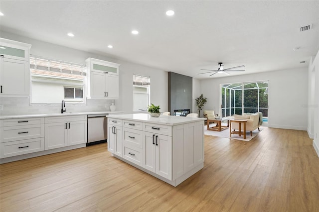 5628 Terrain De Golf Dr, Lutz, FL 33558 - kitchen featuring stainless steel dishwasher, a sink, a ceiling fan, light wood finished floors, and decorative backsplash