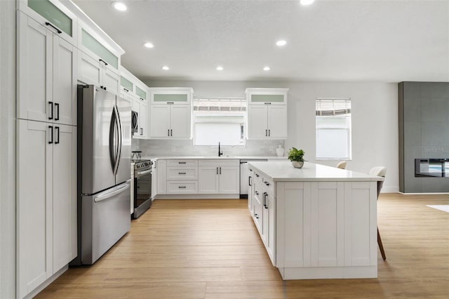 5628 Terrain De Golf Dr, Lutz, FL 33558 - kitchen featuring stainless steel appliances, a kitchen island, recessed lighting, light wood-style floors, and light countertops