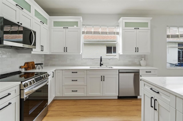 5628 Terrain De Golf Dr, Lutz, FL 33558 - kitchen featuring stainless steel appliances, a sink, backsplash, light countertops, and white cabinets