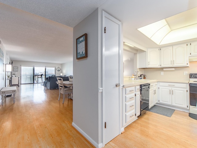 640 Bayway Blvd Unit 302, Clearwater Beach, FL 33767 - kitchen with dishwashing machine, light wood-type flooring, white cabinetry, open floor plan, and a textured ceiling