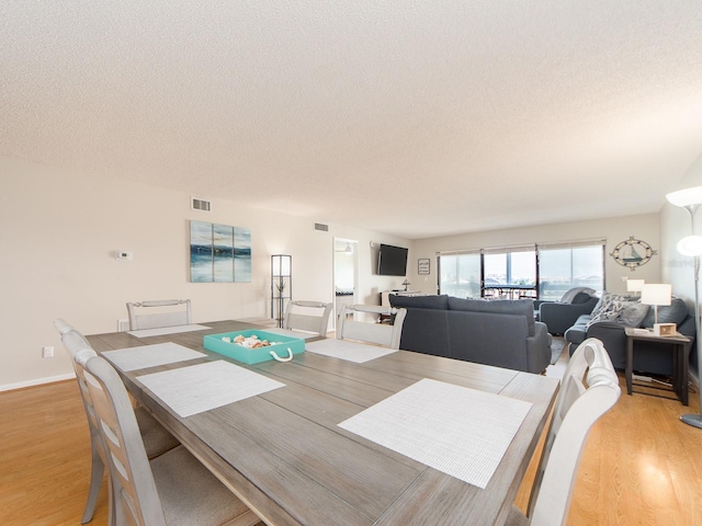 640 Bayway Blvd Unit 302, Clearwater Beach, FL 33767 - dining space with a textured ceiling and light wood-style floors