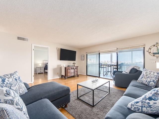 640 Bayway Blvd Unit 302, Clearwater Beach, FL 33767 - living room featuring light wood finished floors and a textured ceiling