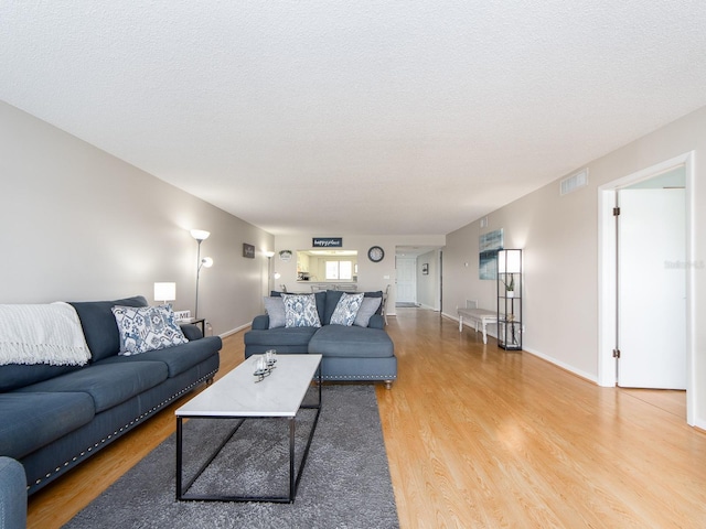 640 Bayway Blvd Unit 302, Clearwater Beach, FL 33767 - living room with wood finished floors, a textured ceiling, and baseboards