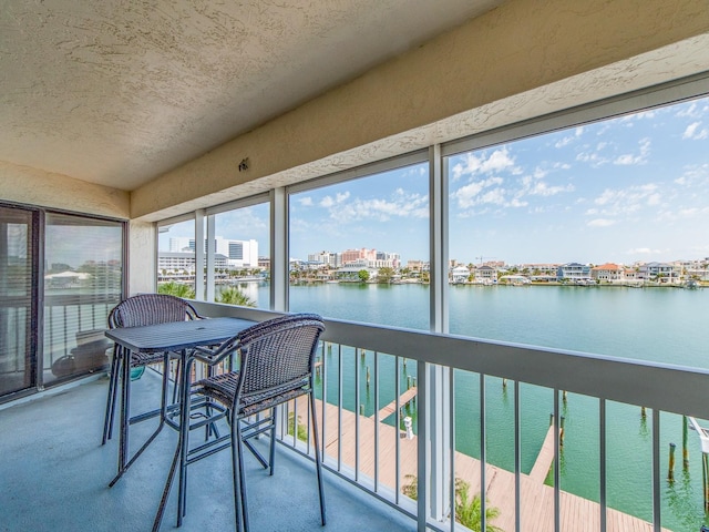 640 Bayway Blvd Unit 302, Clearwater Beach, FL 33767 - sunroom / solarium with a water view, a textured wall, a textured ceiling, and carpet flooring