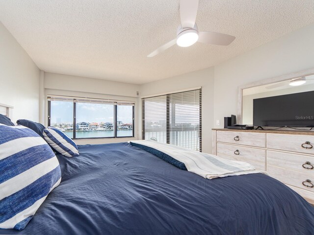 640 Bayway Blvd Unit 302, Clearwater Beach, FL 33767 - bedroom featuring access to outside, a textured ceiling, multiple windows, and ceiling fan