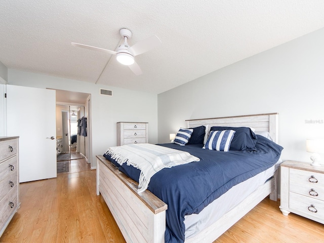 640 Bayway Blvd Unit 302, Clearwater Beach, FL 33767 - bedroom with light wood finished floors, a textured ceiling, and ceiling fan