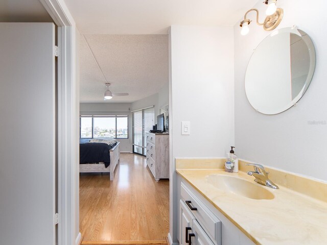 640 Bayway Blvd Unit 302, Clearwater Beach, FL 33767 - ensuite bathroom with wood finished floors, vanity, and a textured ceiling