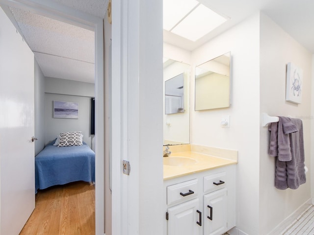 640 Bayway Blvd Unit 302, Clearwater Beach, FL 33767 - bathroom with vanity, wood finished floors, and ensuite bathroom