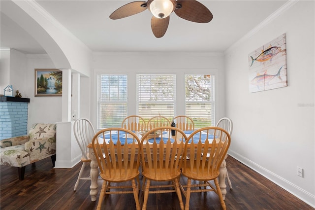 dining area featuring hardwood / wood-style flooring, arched walkways, baseboards, a ceiling fan, and crown molding