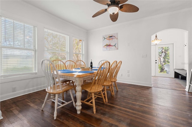dining area with hardwood / wood-style flooring, ornamental molding, baseboards, ceiling fan, and arched walkways