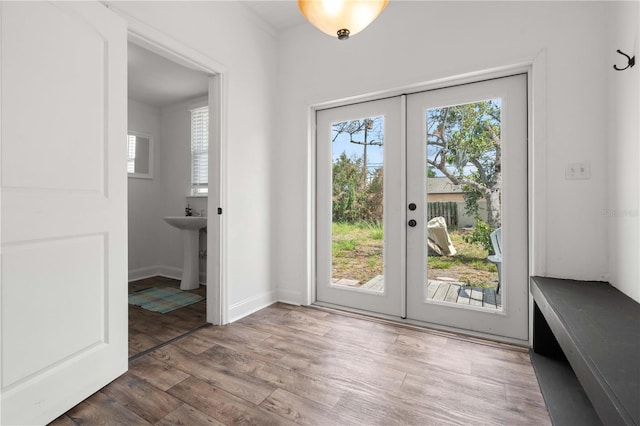 doorway featuring healthy amount of natural light, french doors, wood finished floors, and baseboards