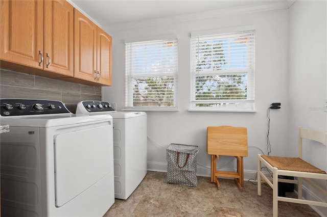 washroom with washing machine and dryer, ornamental molding, cabinet space, and baseboards