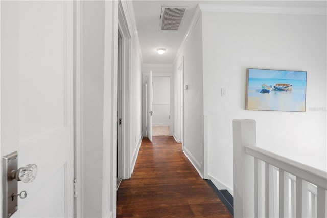 hallway with dark wood-type flooring, crown molding, an upstairs landing, and baseboards
