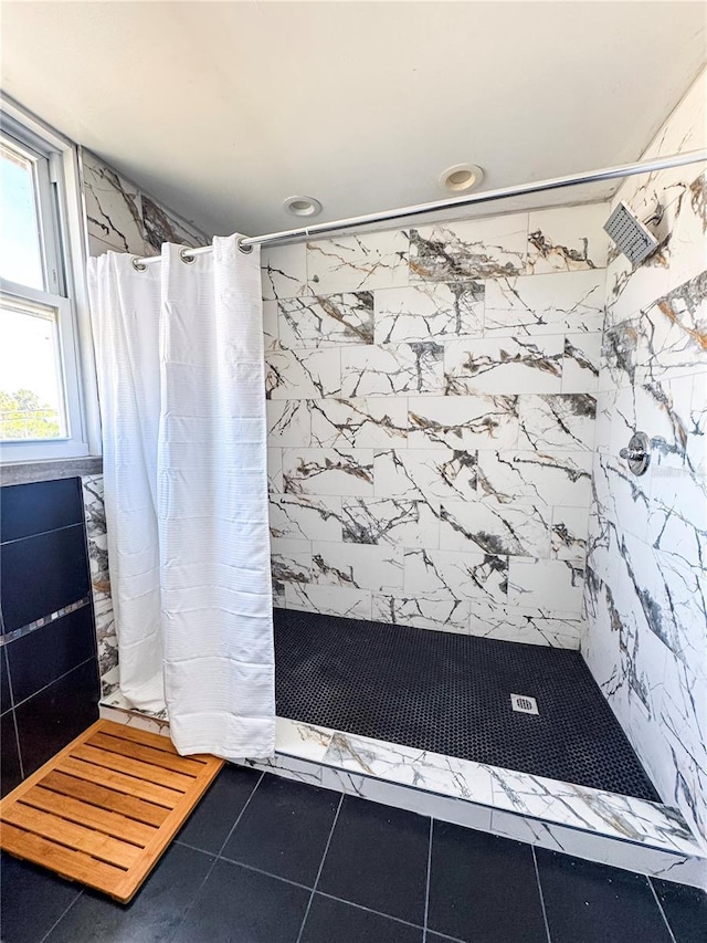 bathroom with a stall shower and tile patterned floors
