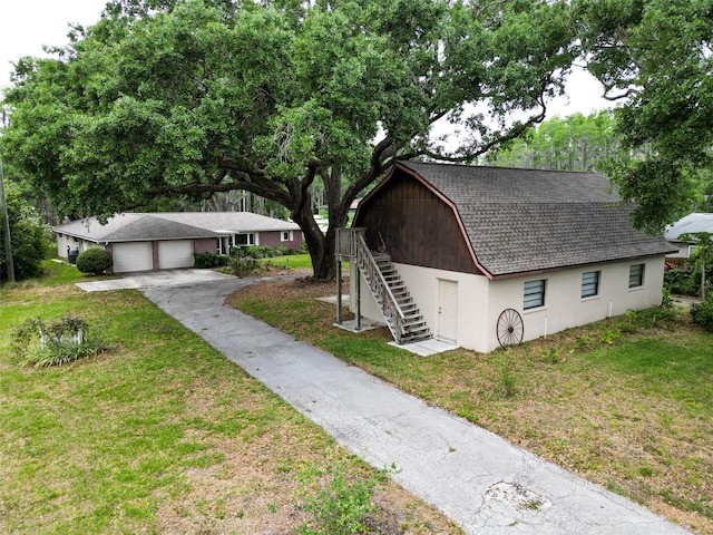 7216 N Mobley Rd, Odessa, FL 33556 - view of front of house with stairway, an attached garage, a gambrel roof, an outdoor structure, and a front lawn