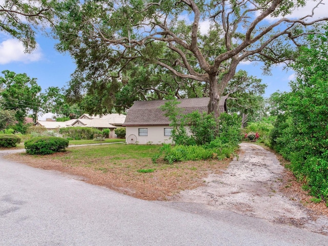 7216 N Mobley Rd, Odessa, FL 33556 - view of side of property featuring stucco siding and a shingled roof