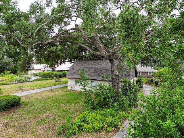 7216 N Mobley Rd, Odessa, FL 33556 - view of side of property with a shingled roof, a lawn, and stucco siding
