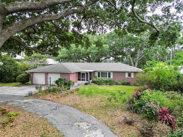 7216 N Mobley Rd, Odessa, FL 33556 - single story home featuring brick siding, a garage, concrete driveway, and a front yard