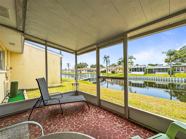 sunroom featuring a water view and a residential view