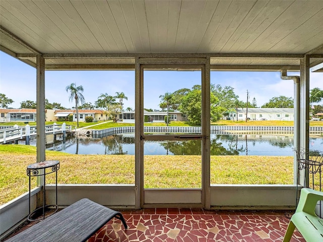 sunroom with a water view and a residential view
