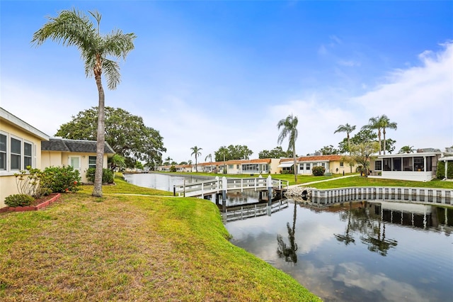 dock area with a water view and a lawn