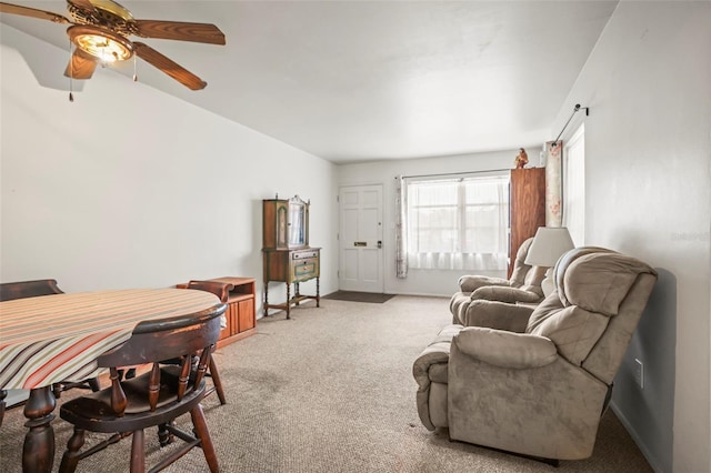 carpeted living room featuring ceiling fan and baseboards