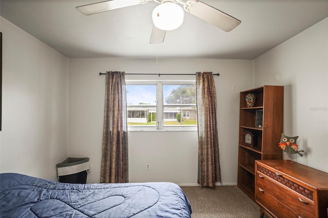 carpeted bedroom with ceiling fan and baseboards