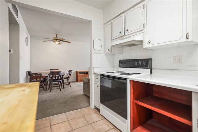 kitchen featuring white electric range oven, under cabinet range hood, light carpet, ceiling fan, and white cabinets