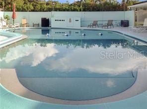 community pool featuring fence and a patio