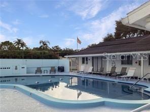 community pool with fence and a patio area