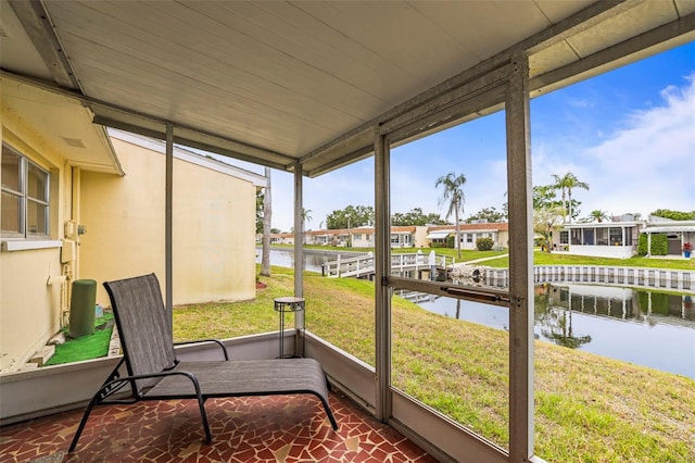 sunroom / solarium featuring a water view and a residential view