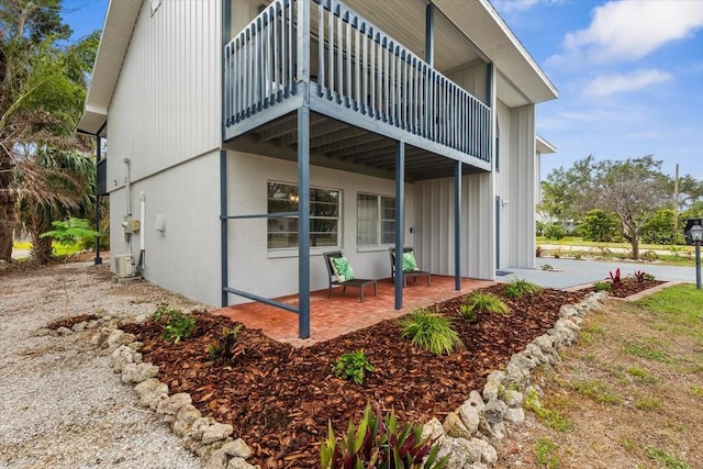 back of property featuring board and batten siding and central AC