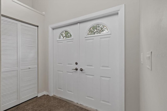 foyer with dark carpet and baseboards