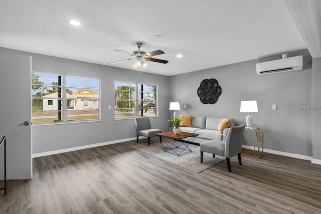 living room with a wall unit AC, baseboards, wood finished floors, and recessed lighting