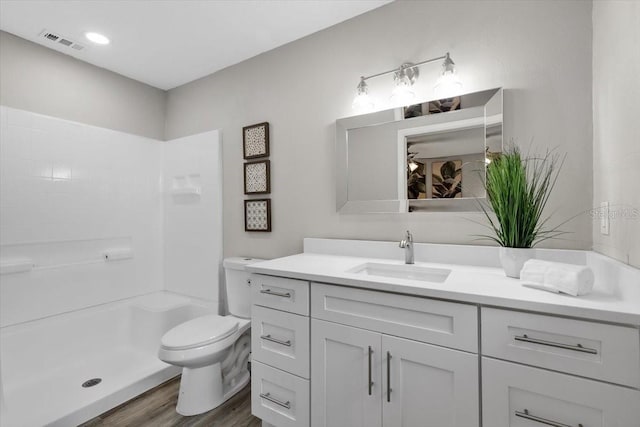 full bath featuring wood finished floors, vanity, toilet, and a shower