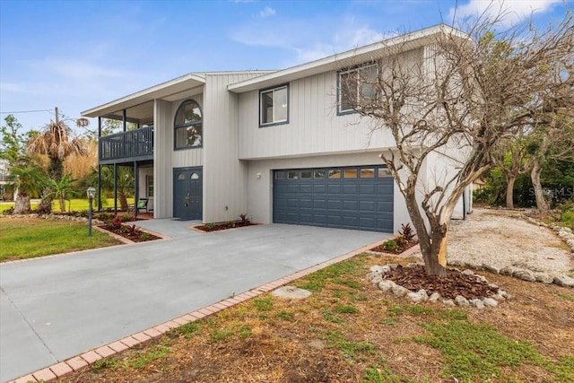 view of front of property with a balcony, driveway, and an attached garage