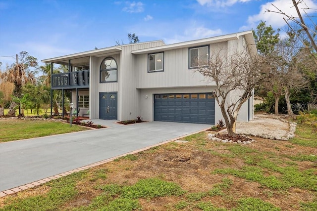 view of front of property featuring a balcony, concrete driveway, an attached garage, and a front lawn