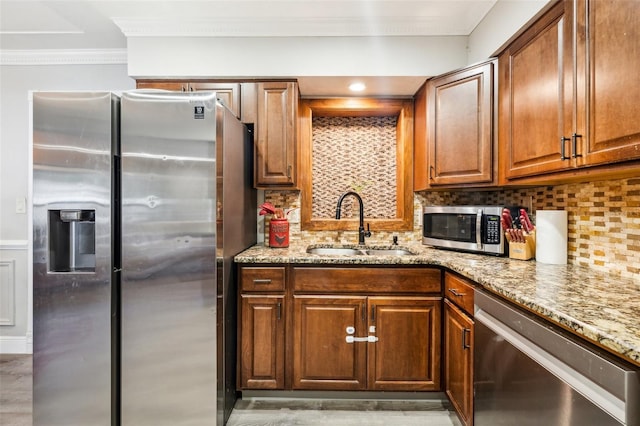 5245 18th St N, Saint Petersburg, FL 33714 - kitchen featuring stainless steel appliances, a sink, light stone counters, crown molding, and backsplash