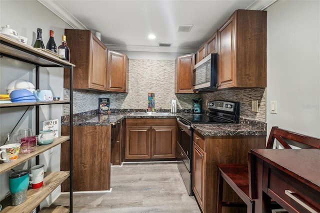 5245 18th St N, Saint Petersburg, FL 33714 - kitchen with stainless steel appliances, decorative backsplash, ornamental molding, light wood-style flooring, and a sink