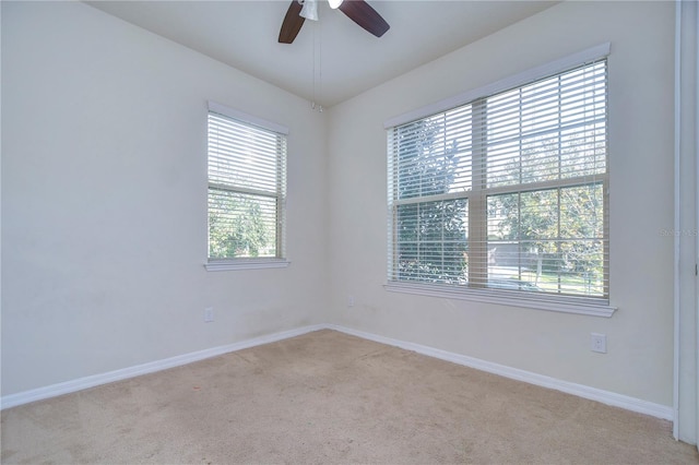 carpeted empty room with baseboards and ceiling fan