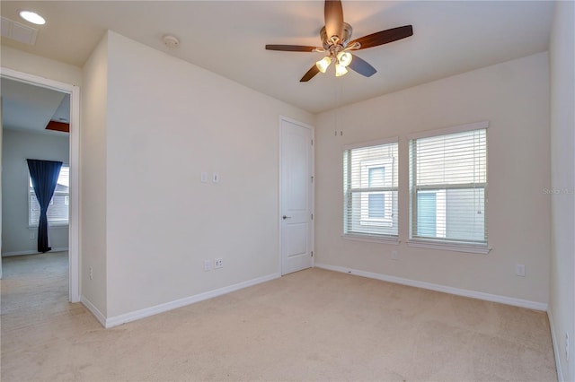 spare room with light carpet, baseboards, ceiling fan, and a smoke detector