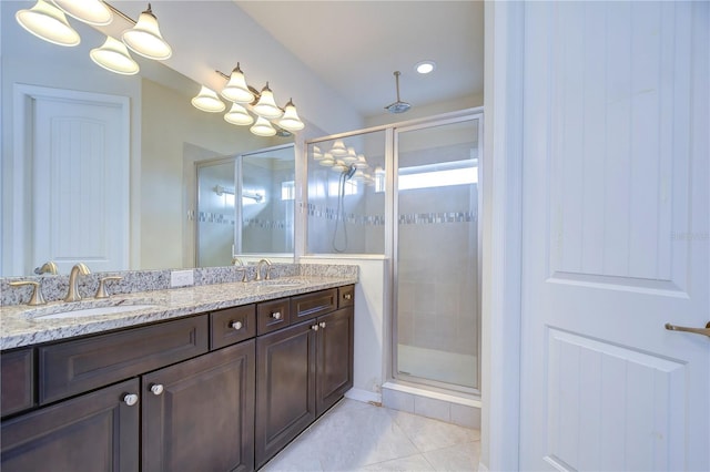 full bath featuring a shower stall, double vanity, and tile patterned floors