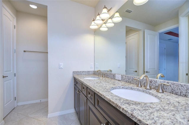 full bathroom with double vanity, a chandelier, and baseboards