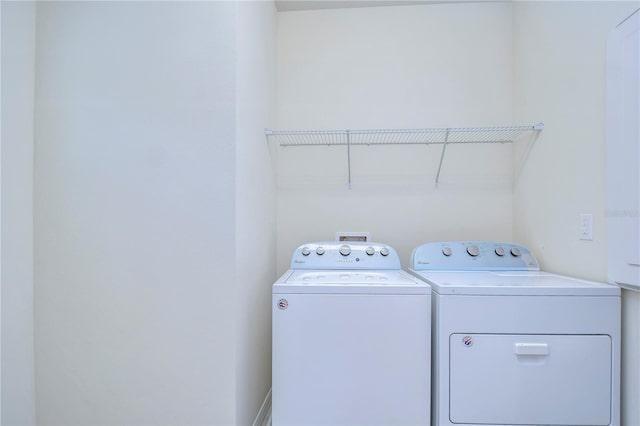 clothes washing area with washing machine and dryer